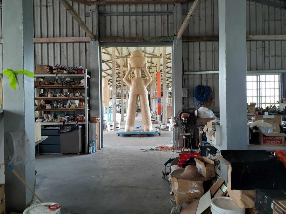 工作室一景，從室內區域望向半露天的工作場域。室內與半戶外的區域分區規劃，適合不同類型創作的進行。